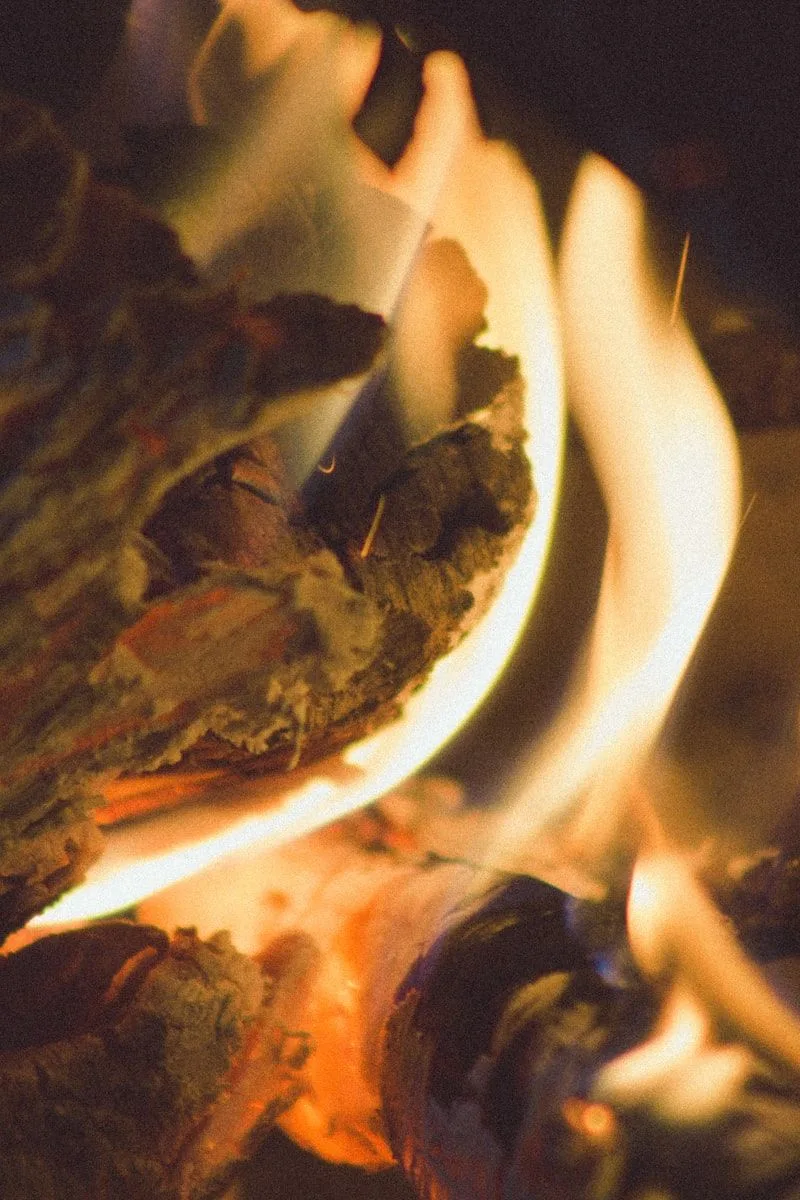 A small fire burning in a white ceramic bowl, representing elemental transformation