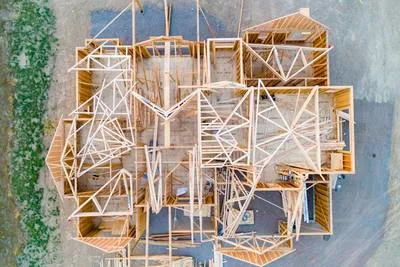 A beige wooden house layout blueprint on a desk, architectural floor plan viewed from above