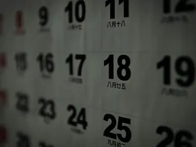 Close-up of a Chinese daily calendar showing large Gregorian dates with small lunar dates printed beneath each one