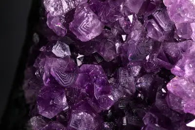 Un racimo de cristal de amatista natural con caras geométricas y líneas de crecimiento internas visibles